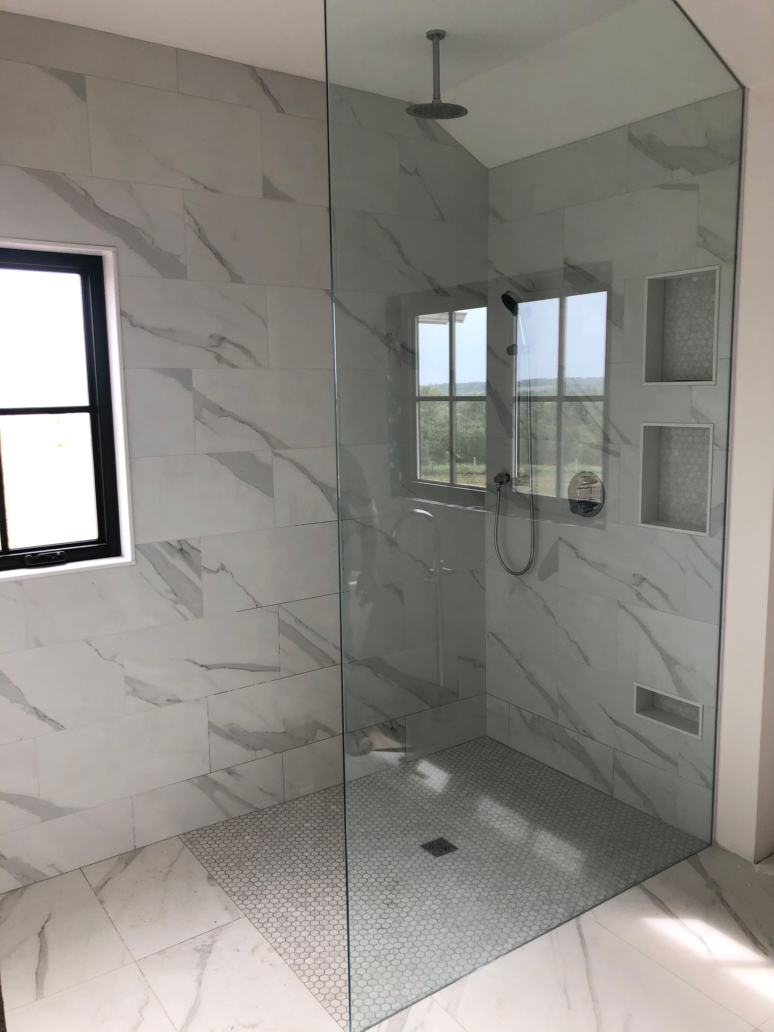 Marble-look shower with hexagonal floor tiles