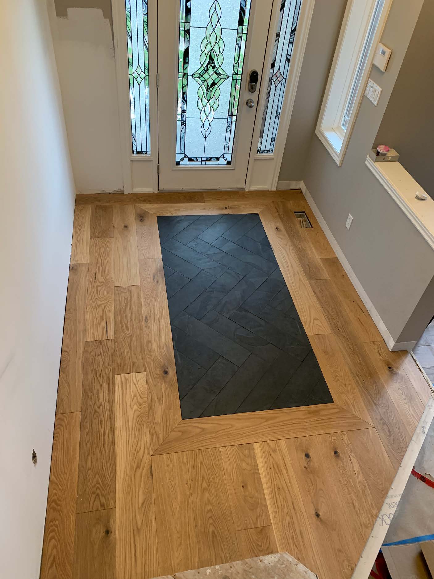 Dark herringbone tile inset in entryway