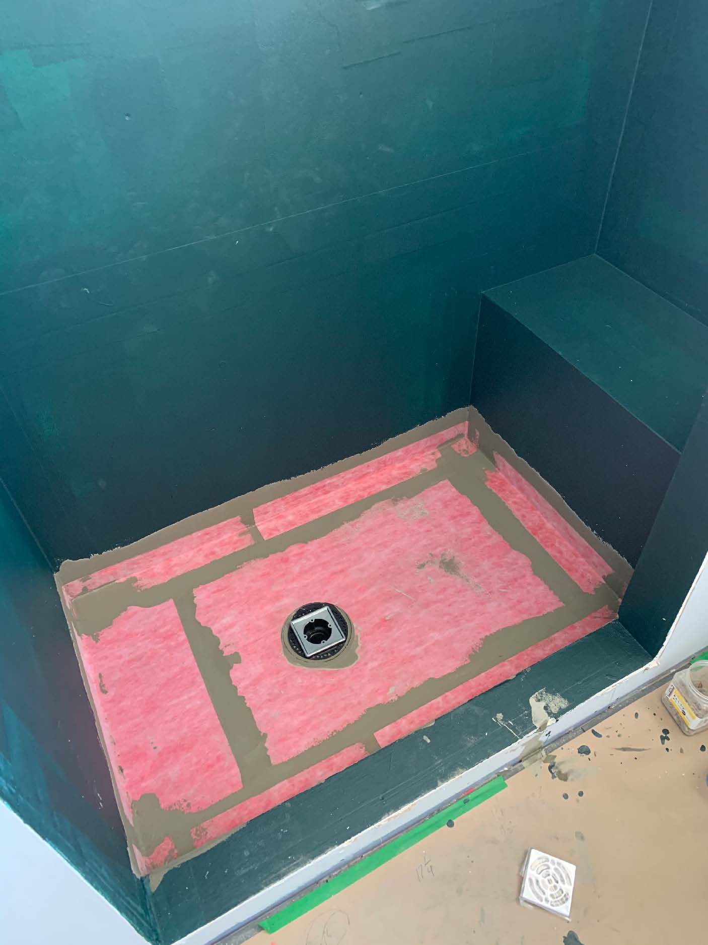 Teal waterproofed shower floor with drain
